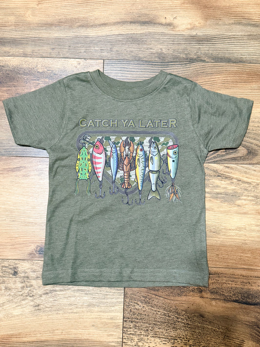 Green t-shirt with fishing lure graphic and 'Catch Ya Later' text on a wooden surface