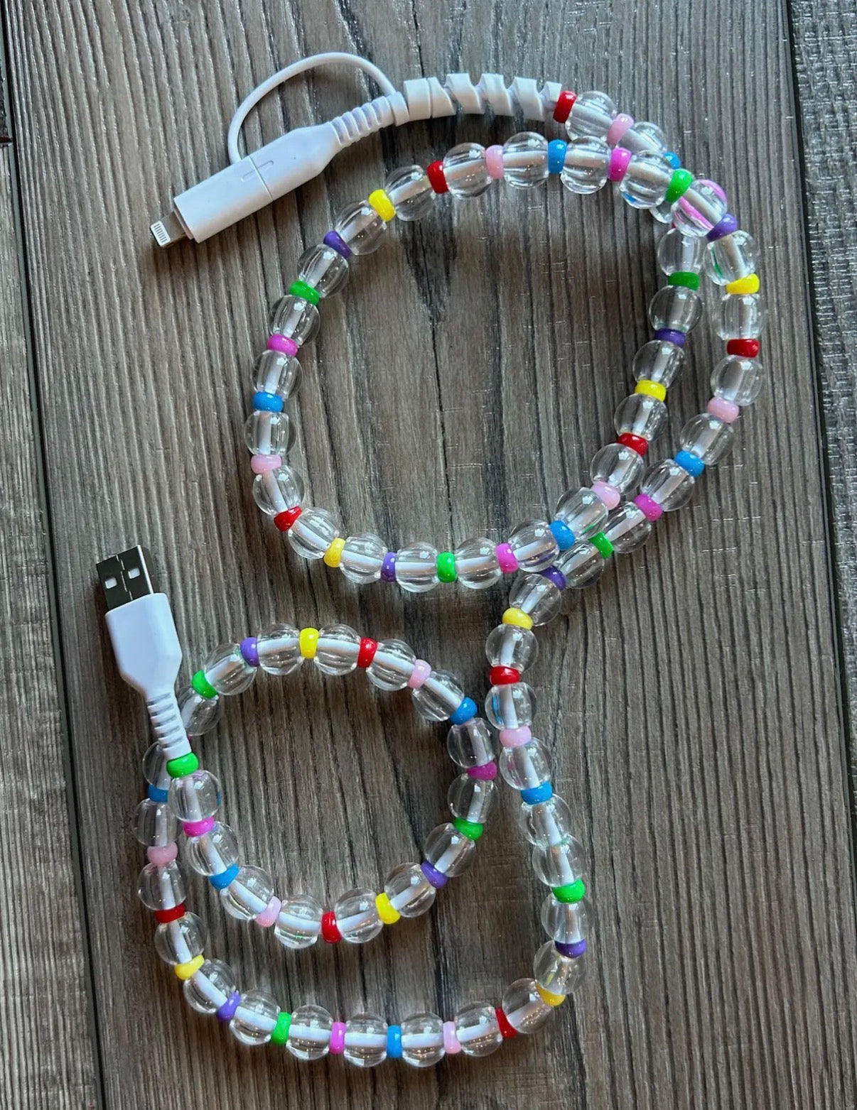 Colorful beaded USB cable on a wooden surface