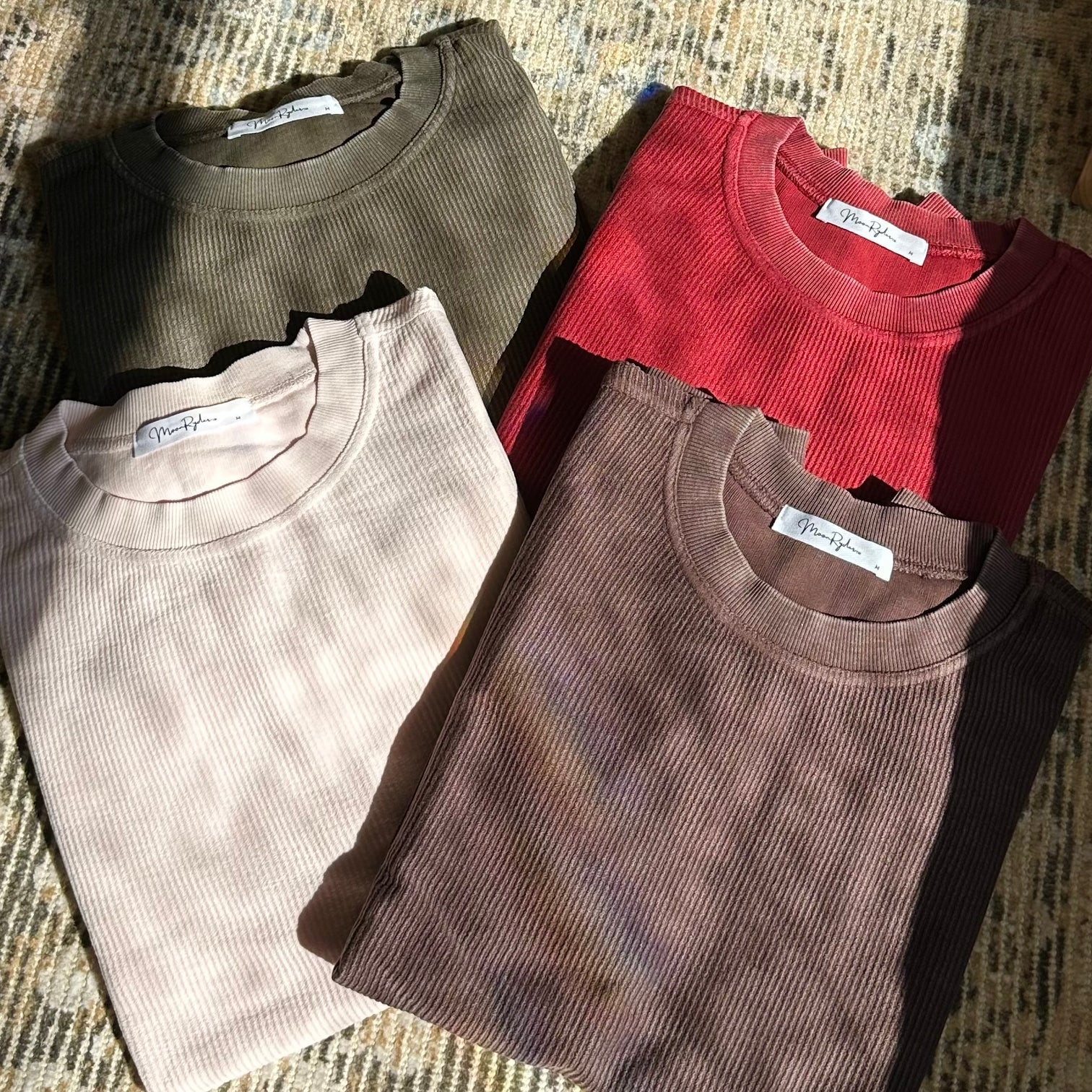 Four folded corded crews  in different colors on a textured surface