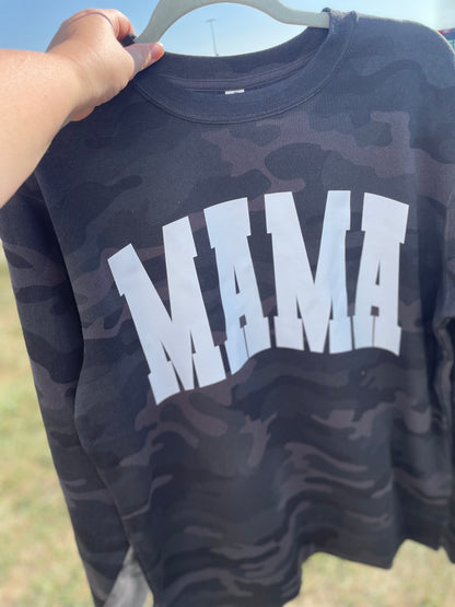 Black camouflage-patterned sweatshirt with 'MAMA' text on a hanger.