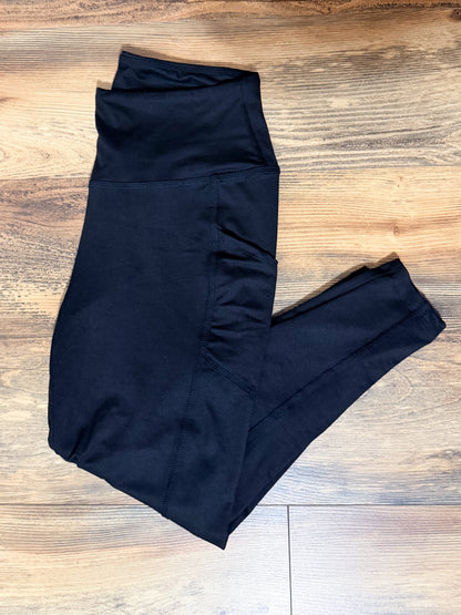 Black leggings folded on a wooden floor