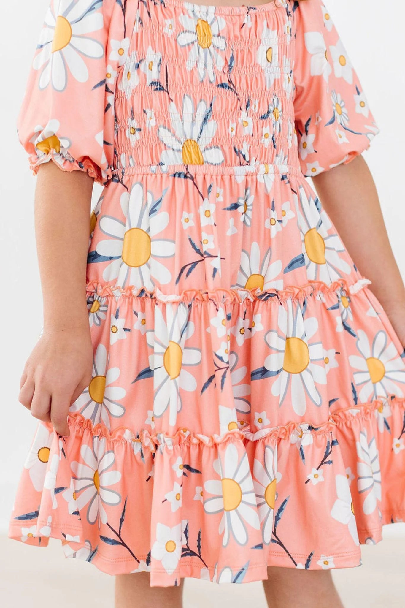 Pink dress with white daisy pattern on a plain background