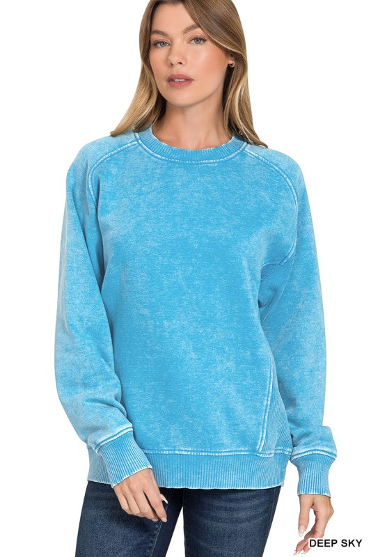 Woman wearing a blue sweatshirt with a plain background