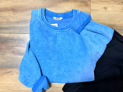 Blue sweater on a wooden surface