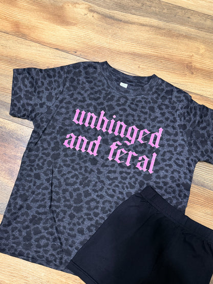 Black leopard print t-shirt with pink text on a wooden surface