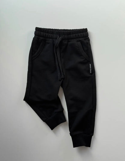 Black jogger pants on a light gray background