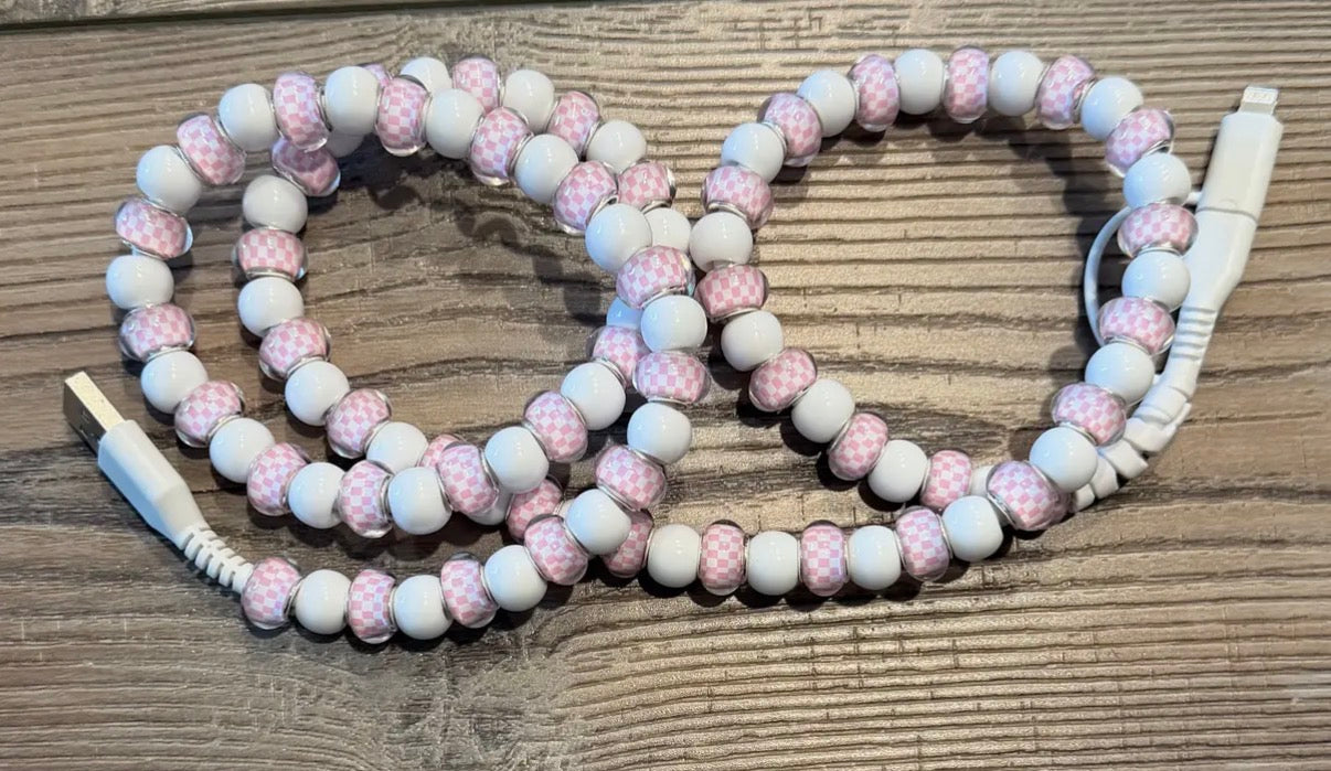 Beaded charger with pink and white beads on a wooden surface