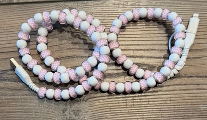 Beaded charger with pink and white beads on a wooden surface