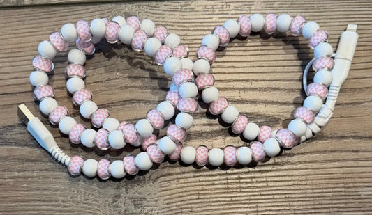 Beaded charger with pink and white beads on a wooden surface