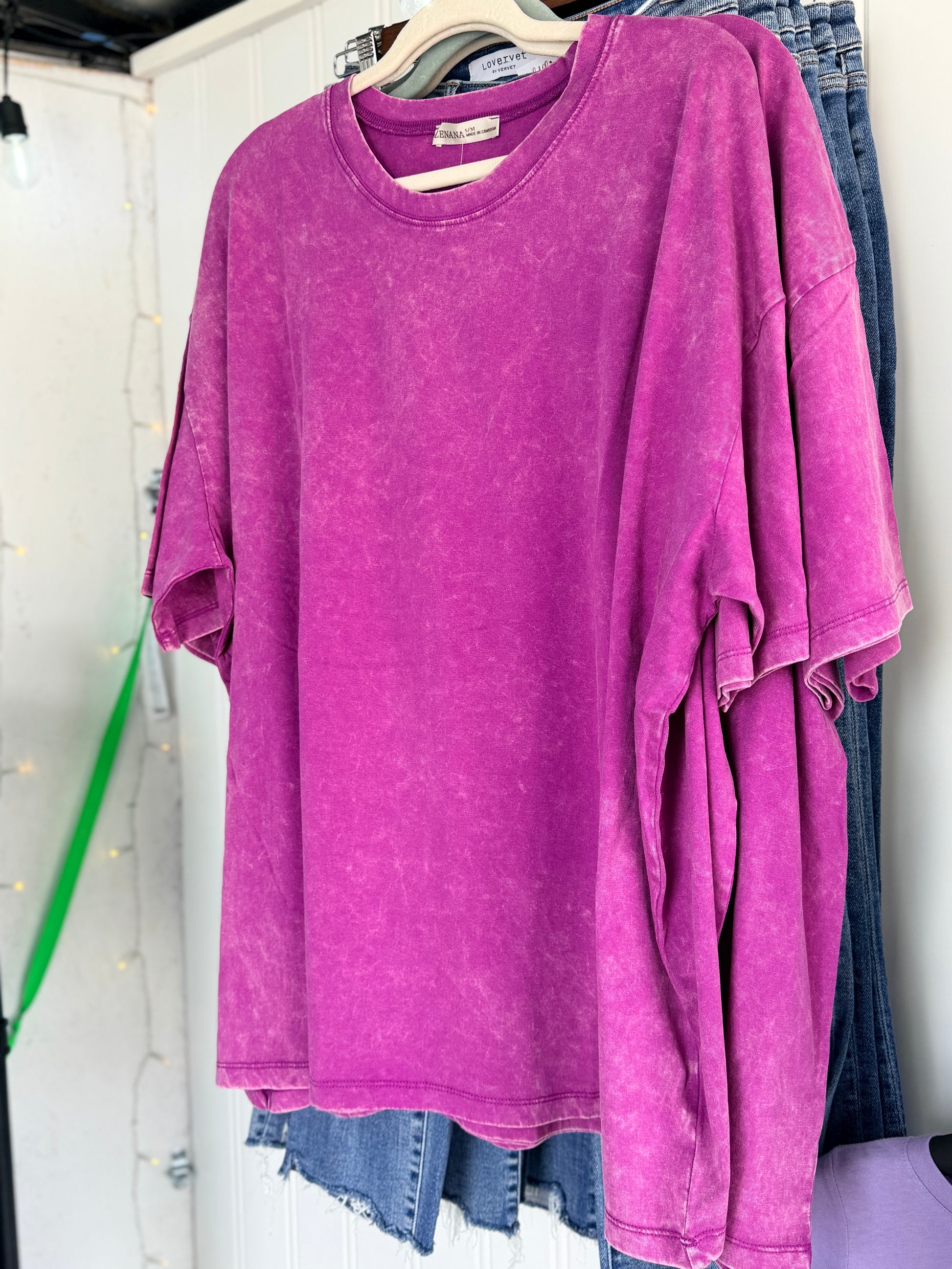 Plum shirt on a hanger with a white background