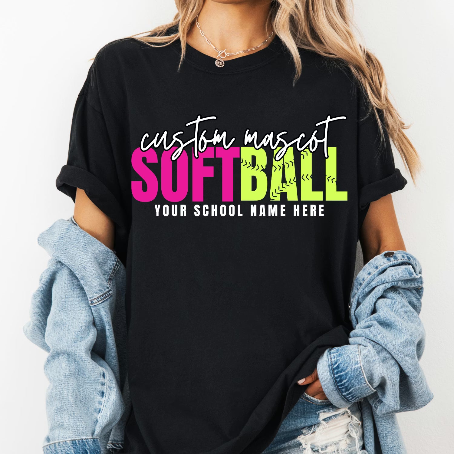 Black t-shirt with 'custom mascot SOFTBALL YOUR SCHOOL NAME HERE' text, worn by a person with a denim jacket.