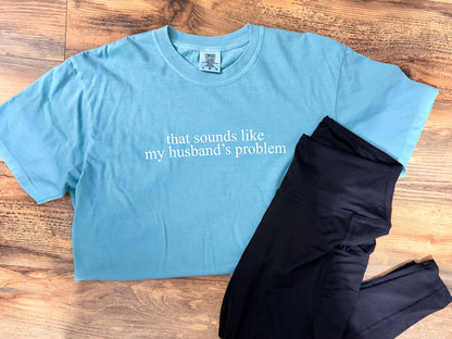 Blue t-shirt with text and black leggings on a wooden surface