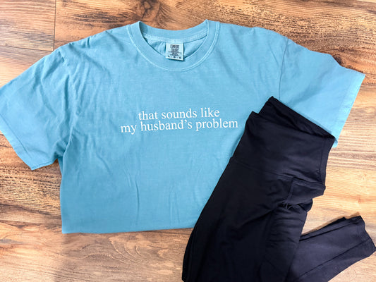 Blue t-shirt with text and black leggings on a wooden surface