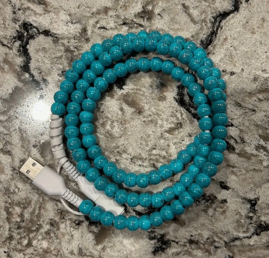 Turquoise beaded cable with USB connector on a marble surface
