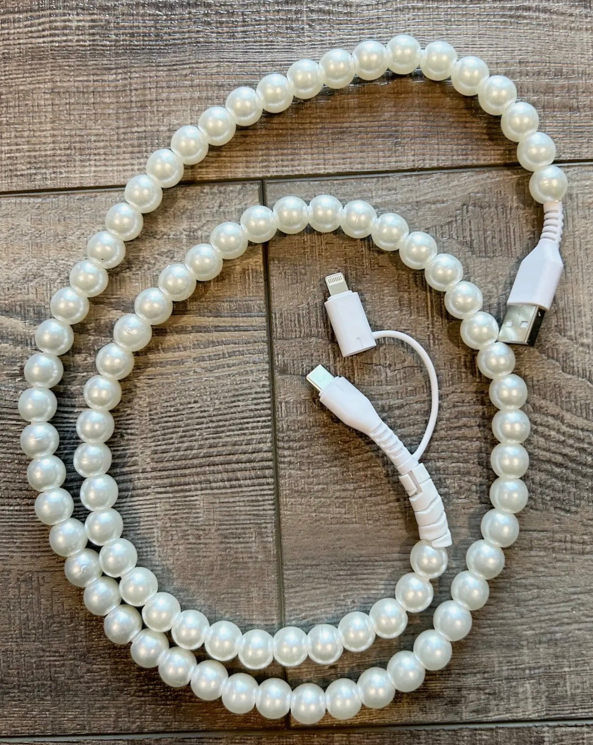White pearl charger with USB cable on a wooden surface