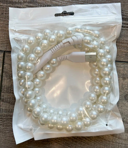 Pearl-colored USB cable coiled inside a clear plastic bag on a wooden surface