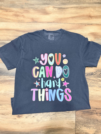Pepper grey t-shirt with colorful text on a wooden surface